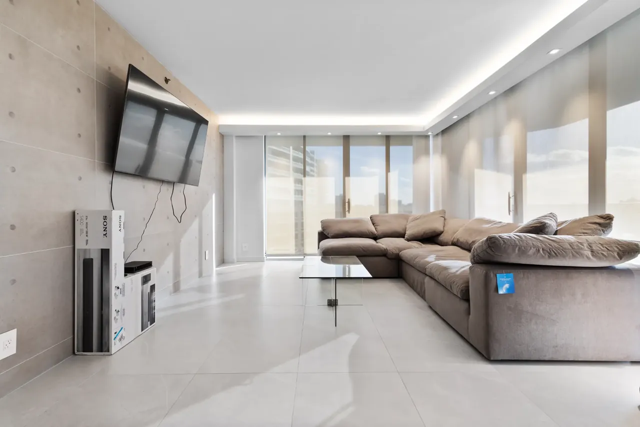 Finished South Florida living room with tile flooring and contemporary built-in wall