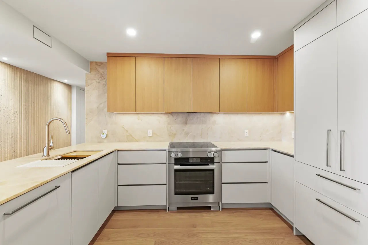 Finished contemporary kitchen with warm wood cabinetry and stone backsplash
